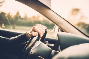 Man driving a car, close up on a steering wheel